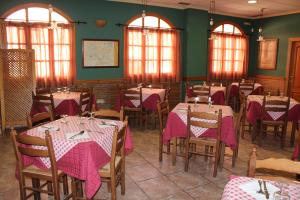 a dining room with tables and chairs with pink table cloth at La Posá in Villar del Arzobispo