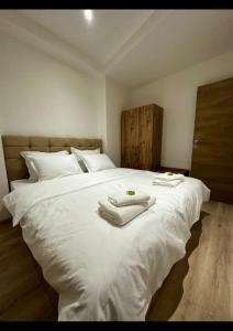 ein Schlafzimmer mit einem großen weißen Bett mit Handtüchern darauf in der Unterkunft Center Apartments The Quiet Luxury 1 in Plowdiw