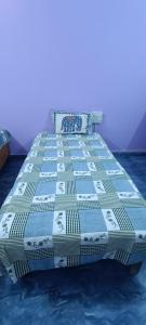 a bed with a blue and white quilt on it at Hotel Ashu , Ntl Road in Haldwāni +2 photos