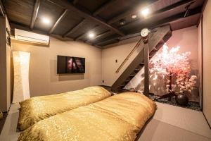 a room with a bed and a staircase with a clock at おやど紀伊国屋籠町 in Nagasaki