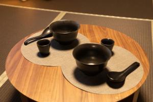 a table with black bowls and spoons on it at おやど紀伊国屋籠町 in Nagasaki