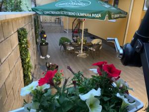 einen Blick über eine Terrasse mit Blumen und einem Sonnenschirm in der Unterkunft Center Apartments The Quiet Luxury 1 in Plowdiw