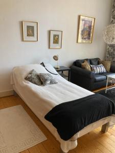una camera da letto con un letto grande e un divano di Rum mitt i centrala Helsingborg a Helsingborg