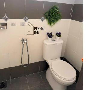 a bathroom with a toilet with flowers on the wall at Roomstay Homestay Permai Inn Pekan in Pekan