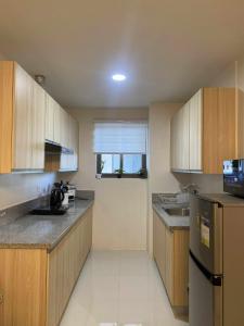 een keuken met houten kasten en een koelkast bij Casa Moderna Iloilo in Iloilo City