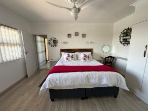 a bedroom with a large bed with a red blanket at Strelitzia, spacious with a stunning view in Cape Town +42 photos