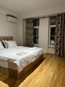 ein Schlafzimmer mit einem großen Bett und zwei Fenstern in der Unterkunft Center Apartments The Quiet Luxury 3 in Plowdiw
