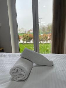 ein Handtuch auf einem Bett mit einem Fenster in der Unterkunft Dea sobe in Posušje