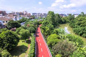 a red train traveling down a road in a city at Grand Bravo Guilin in Guilin