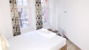 ein weißes Zimmer mit einem Bett und einem Fenster in der Unterkunft Center Apartments The Quiet Luxury 3 in Plowdiw + 6 Fotos