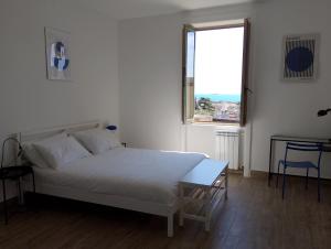 a white bed in a room with a window at Almarisa - appartamento vista mare in Salerno