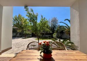 un tavolo in legno con sedie e fiori su un patio di The seaside villa - Anzio ad Anzio