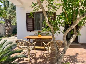 un patio con tavolo, sedie e un albero di The seaside villa - Anzio ad Anzio