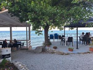 a group of people sitting at tables near the ocean at Diana Apartment Briatico in Briatico