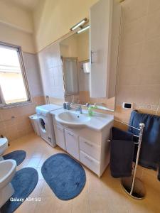 a bathroom with a sink and a toilet and a mirror at Diana Apartment Briatico in Briatico +37 photos