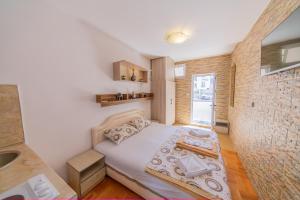 a small bedroom with a bed and a sink at Azzuro apartments Budva in Budva