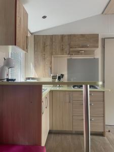 a kitchen with wooden cabinets and a counter top at Mobil-home in Agde