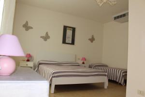 カヴァッリーノ・トレポルティにあるMarelaguna Roomsの蝶が壁に描かれた部屋のベッド2台