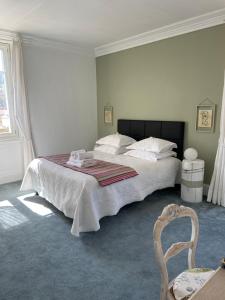 a bedroom with a large bed and a chair at Le Passagran in Boën