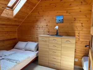una camera da letto in una baita di tronchi con un letto e una lampada di Błękit a Sarbinowo