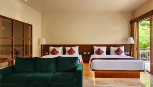 a hotel room with a bed and a couch at Sapodilla Ubud in Ubud