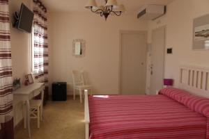 カヴァッリーノ・トレポルティにあるMarelaguna Roomsのベッドルーム1室(ベッド1台、テーブル、デスク付)