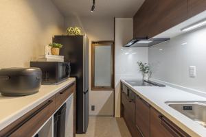 a kitchen with a sink and a microwave at Kstyle Apartments UNO in Tamano