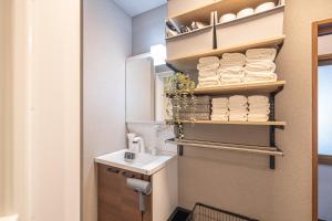 a bathroom with a sink and a toilet and towels at Kstyle Apartments UNO in Tamano