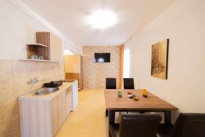 a kitchen with a wooden table and a dining room at Azzuro apartments Budva in Budva