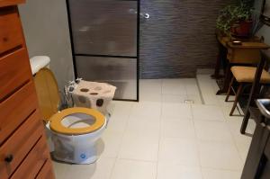 a bathroom with a toilet with a wooden seat at La Esmeralda: El Alojamiento estrella de Amaicha del Valle in Amaichá del Valle