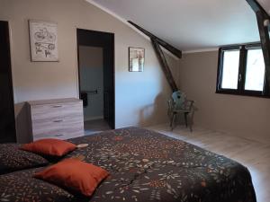 BourrouillanGîte Au Moulin du Comte的带床、梳妆台和窗户的卧室