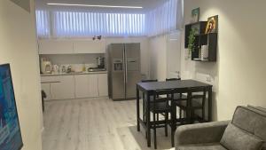 a living room with a table and a kitchen at שלווה במעיינות in Bet Sheʼan