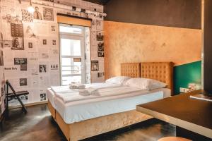 a bed in a room with a wall with pictures at Timeout Heritage Hotel Zagreb in Zagreb