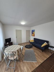 a living room with a blue couch and a table at COM Home Floresti in Floreşti
