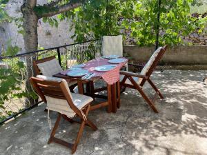 a wooden table with two chairs and a table with plates at Sweet holiday house in Veli Iž
