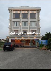 BelagulaHotel White Palace的一栋建筑前停着一辆车
