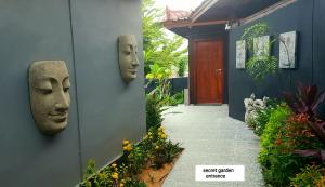 two masks on the side of a building with a walkway at Secret Garden Surf Resort, walk to waves in Pulau Gilkaliantan +15 photos