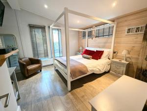 a bedroom with a canopy bed and a chair at 1 or 2 bedroom Hot tub Lodges in North Walsham