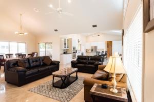 a living room with a couch and a table at Golden Sands Emerald - Florida's Best - ALL Private Beachfront Estate with TENNIS-PICKLEBALL Court, Pool, Spa in Indialantic