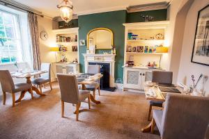 a living room with a table and chairs and a fireplace at Market Cross Guest House in Belford