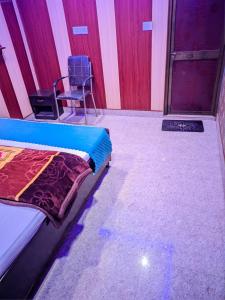AyodhyaにあるGupta Homestayのベッドと椅子が備わる部屋
