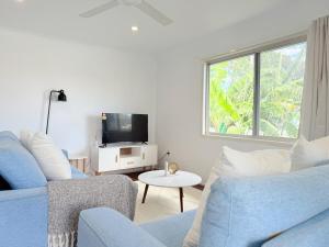a living room with a blue couch and a tv at Family Comfort Modern 3BR Retreat in Brisbane +13 photos
