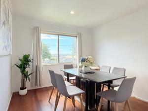 a dining room with a table and chairs and a window at Family Comfort Modern 3BR Retreat in Brisbane