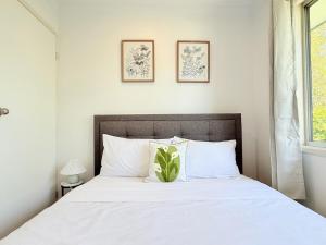 a bedroom with a white bed with a plant on it at Family Comfort Modern 3BR Retreat in Brisbane