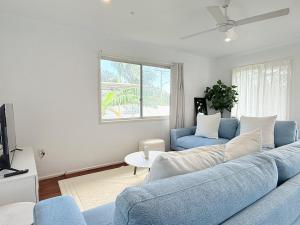 a living room with a blue couch and a tv at Family Comfort Modern 3BR Retreat in Brisbane