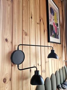 two lights are hanging on a wooden wall at AleWidok - domek z sauną i widokiem na Góry Sowie in Ostroszowice