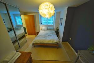 a bedroom with a bed and a large mirror at Broomfield Nook - 2 Bed Ground floor Maisonette close to Harry Potter studio tour in Abbots Langley
