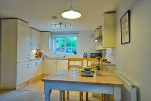 a kitchen with a blue table in a room at Broomfield Nook - 2 Bed Ground floor Maisonette close to Harry Potter studio tour in Abbots Langley