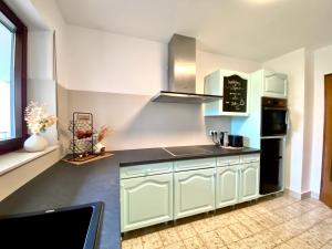 a kitchen with white cabinets and a black counter top at Ferienwohnung Karlstadt in Karlstadt