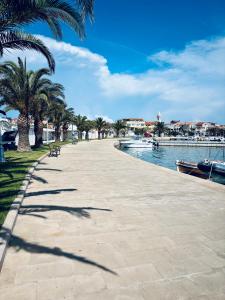 una acera junto a un río con palmeras en Novak House, en Pakoštane 25 fotos más